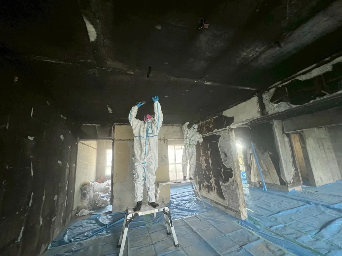 火災現場での復旧作業 防護服スタッフによる清掃